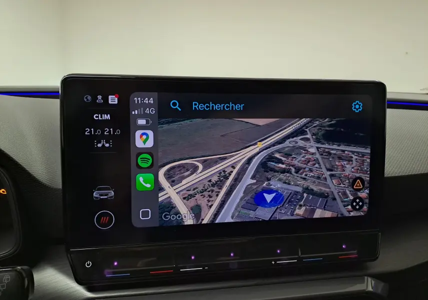 Écran tactile central du tableau de bord de la CUPRA Leon 1.5 eTSI 2023 affichant la navigation GPS et les commandes climatiques.