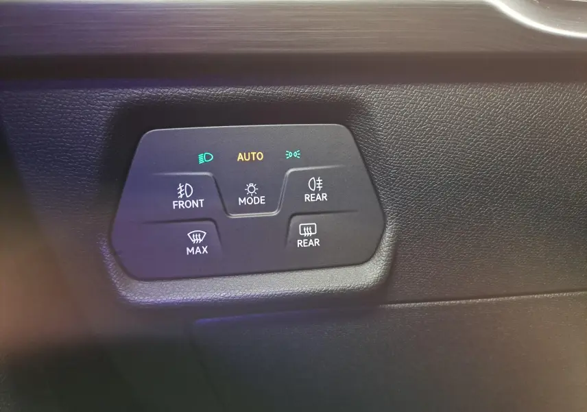 Panneau de commandes d'éclairage avec mode automatique sur tableau de bord noir d'une CUPRA Leon 2023 gris magnétique.