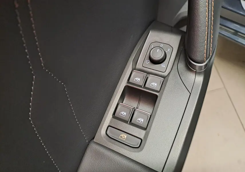 Gros plan sur les commandes de lève-vitres et rétroviseurs côté conducteur d'une CUPRA Leon 2023 gris magnétique.