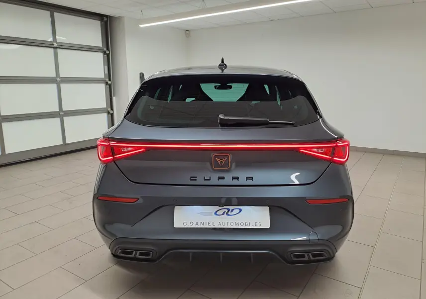 Vue arrière d'une CUPRA Leon 1.5 eTSI 150 ch gris magnétique avec feux LED continus et double sortie d'échappement.