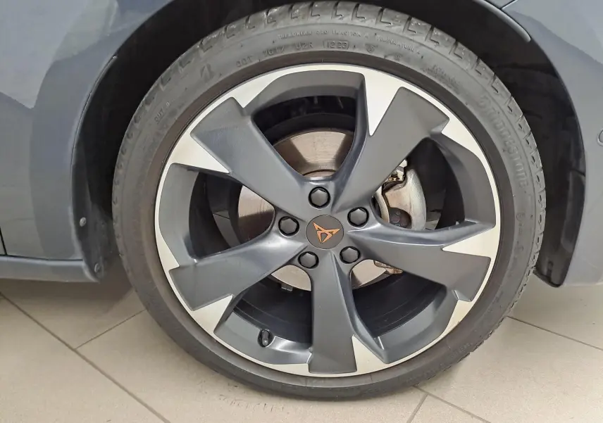 Gros plan sur la roue avant gauche d'une CUPRA Leon 1.5 eTSI gris magnétique avec jante alliage au design moderne.