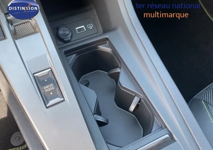 Vue rapprochée de la console centrale de la Peugeot 308 Hybrid blanche, avec porte-gobelets et bouton Drive Mode.