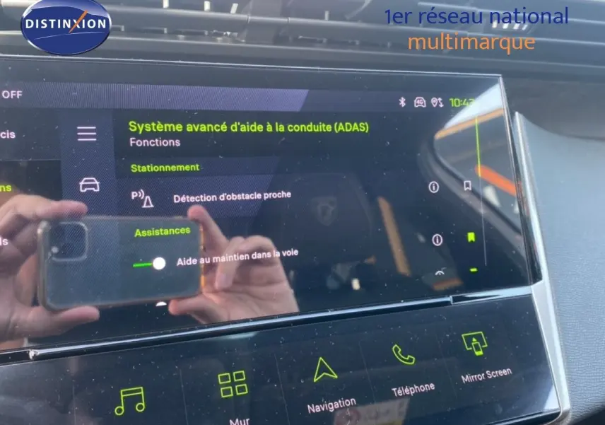 Écran tactile du système d'aide à la conduite dans l'habitacle d'une Peugeot 308 Hybrid blanc, vue rapprochée.