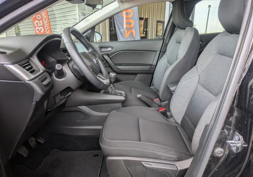 Vue intérieure côté conducteur du Renault Captur Business DCI 95 2020 noir, montrant sièges tissu gris et volant avec boîte manuelle.