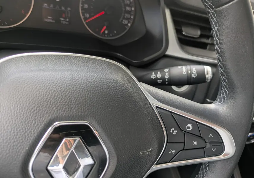 Gros plan sur le volant noir du Renault Captur Business DCI 95 de 2020, avec commandes intégrées et tableau de bord partiel.