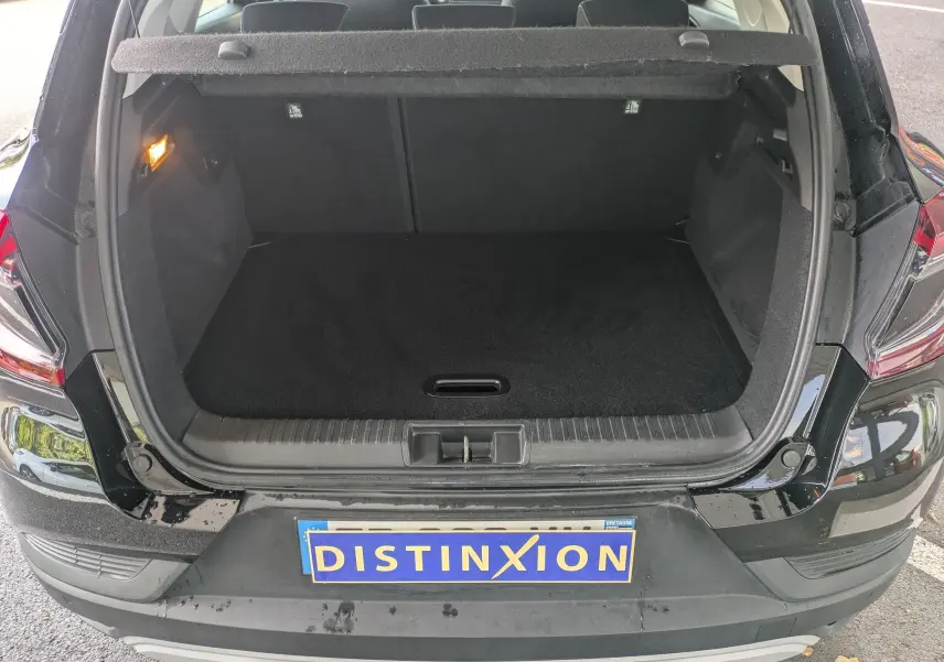 Coffre ouvert vu de l'arrière d'un Renault Captur noir 2020, montrant un espace de chargement vide et propre.