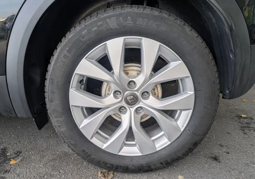 Gros plan sur la roue avant gauche du Renault Captur Business DCI 95 noir avec jante alliage argentée à 10 branches.
