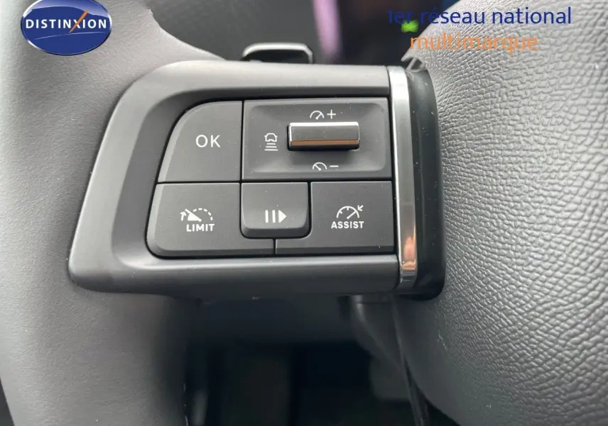 Gros plan sur les commandes au volant du Citroën C4 blanc métal 2024, mettant en valeur les boutons d'assistance et de limitation de vitesse.