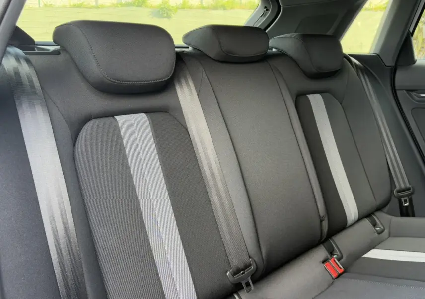 Vue rapprochée de la banquette arrière noire avec bandes grises de l'Audi A3 Sportback 2024, intérieur tissu Konsens.