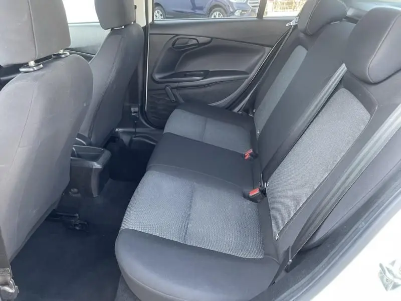 Vue intérieure côté droit des sièges arrière en tissu gris et noir du Fiat Tipo 1.4 street blanc 2019 avec porte ouverte.