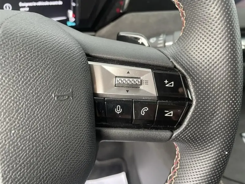 Gros plan sur les commandes vocales et téléphone du volant perforé du DS4 gris hybride rechargeable 2023.