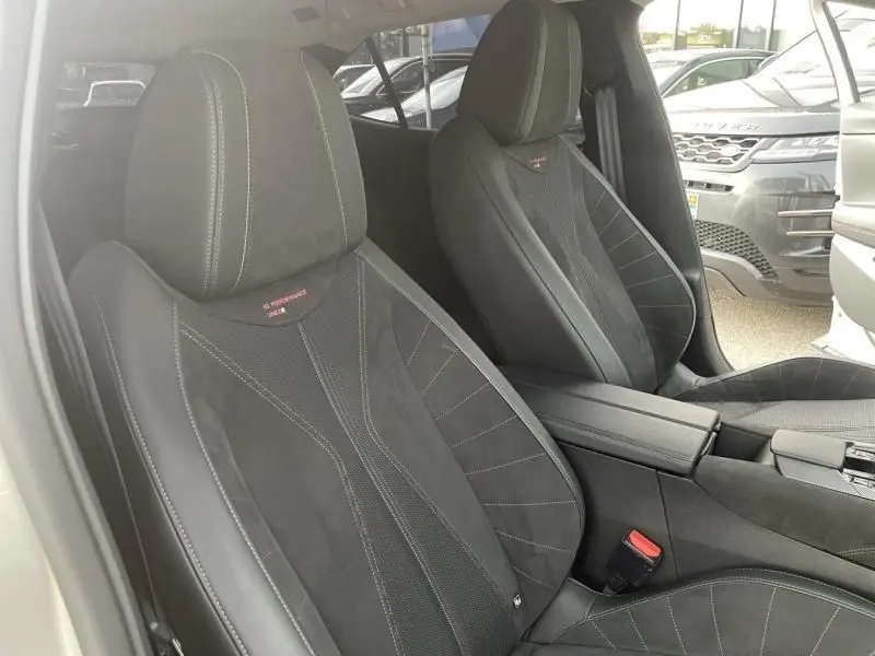 Vue intérieure des sièges avant noirs en cuir et alcantara du DS4 Hybride E-Tense 225 Performance Line 2023, avec surpiqûres blanches.