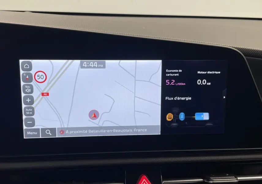 Écran central du Kia Niro 2025 blanc montrant la navigation et le flux d'énergie hybride en intérieur.