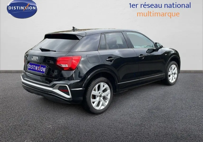 Audi Q2 noir mito metal vue 3/4 arrière droit, soulignant ses feux arrière rouges et jantes argentées.