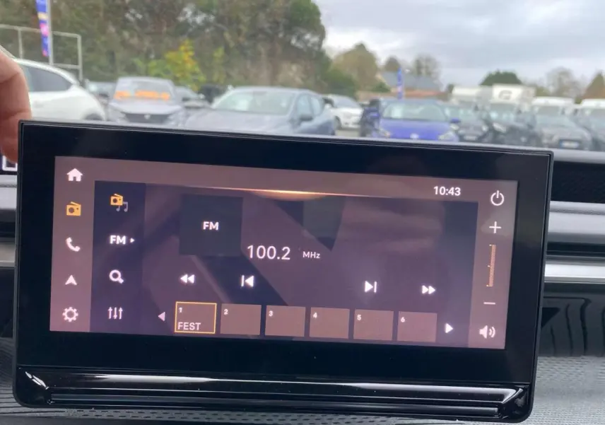 Écran tactile central du tableau de bord du Citroën C3 Aircross 2025, affichant la radio FM à 100.2 MHz.
