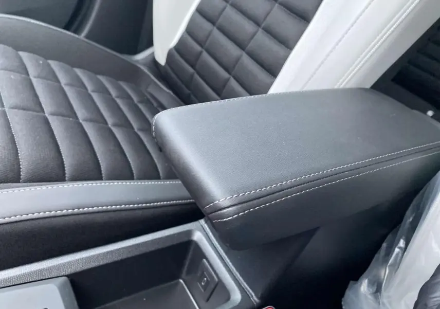 Accoudoir central noir avec surpiqûres blanches et siège avant en tissu noir et blanc du Citroën C3 Aircross.