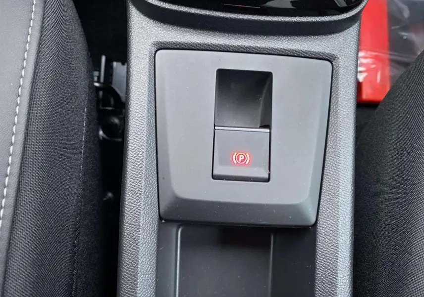 Gros plan sur le frein de stationnement électrique activé dans la console centrale du Citroën C3 Aircross hybride 2025.