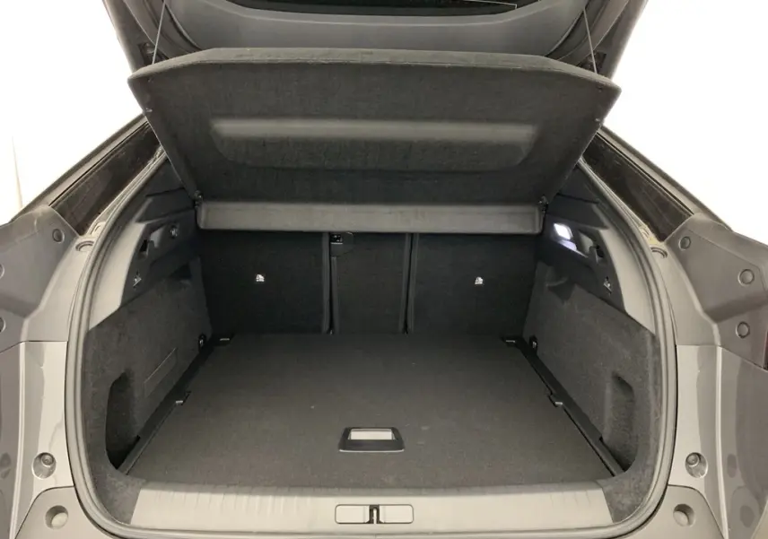 Coffre ouvert vu de l'arrière du Peugeot 3008 Hybrid gris titane avec intérieur noir et hayon motorisé.