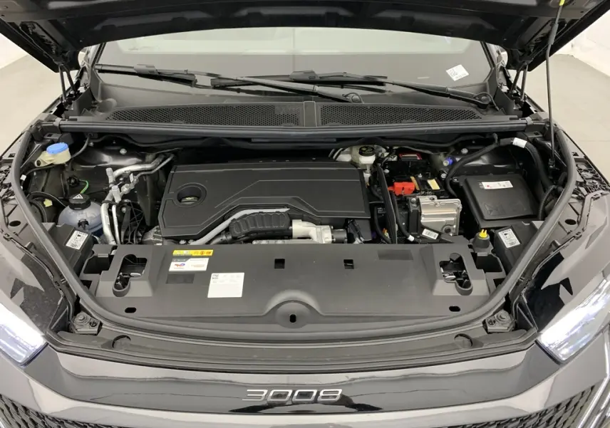 Vue de dessus du compartiment moteur ouvert du Peugeot 3008 Hybrid 145 CH e-DCS6 GT gris titane avec logo 3008 visible sur la calandre noire.