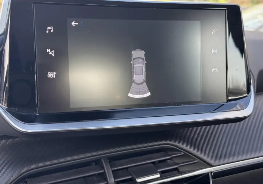 Écran tactile central du tableau de bord de la Peugeot 2008 noir, affichant l'aide au stationnement arrière.