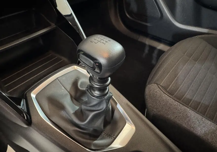 Gros plan sur le levier de vitesses manuel noir et la sellerie tissu gris à motifs du Peugeot 2008 PureTech 130 S&S Active Pack.
