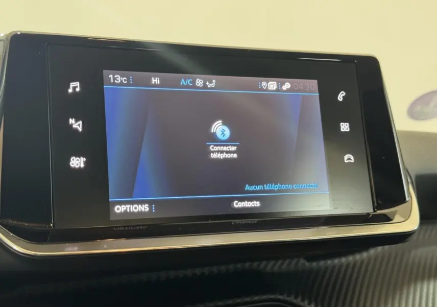 Écran tactile central du tableau de bord du Peugeot 2008 noir, affichant la connexion Bluetooth au téléphone.