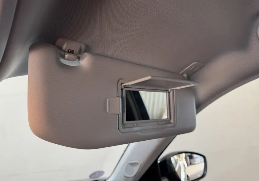 Miroir de courtoisie ouvert sur pare-soleil côté conducteur dans l’habitacle d’un Peugeot 2008 noir.