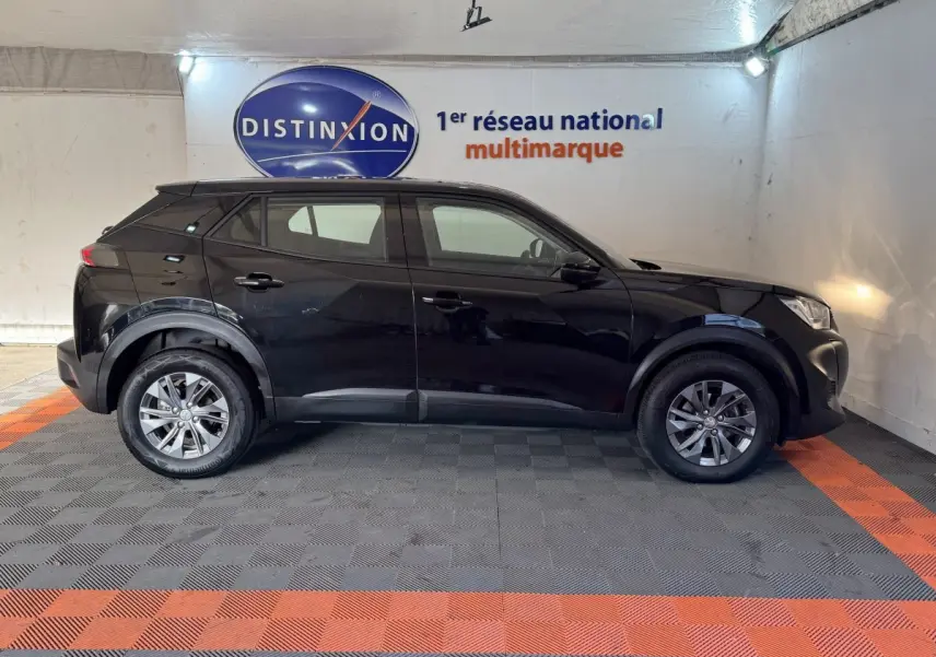 Profil côté gauche d'un Peugeot 2008 noir 2022 PureTech 130 S&S ACTIVE PACK dans un showroom intérieur.