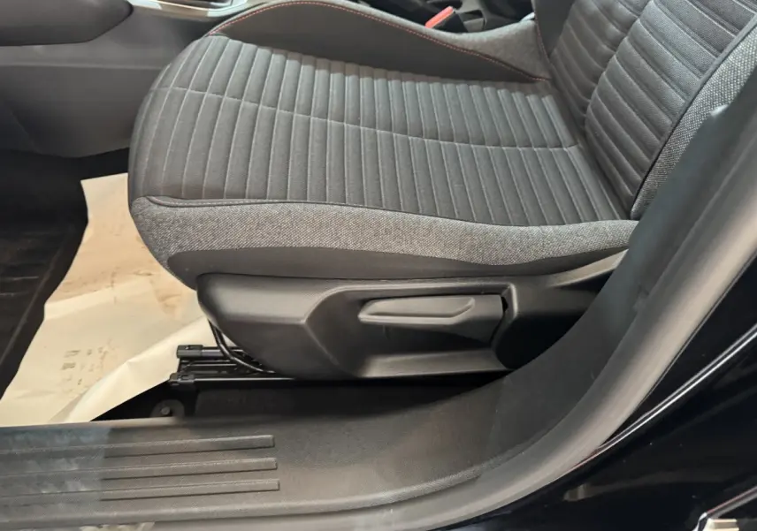 Gros plan sur le siège avant droit gris à surpiqûres rouges du Peugeot 2008 noir, version PureTech 130 S&S ACTIVE PACK.