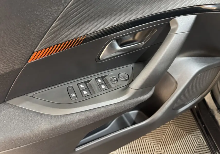 Gros plan sur la porte avant gauche noire du Peugeot 2008 2022, avec commandes des vitres et poignée intégrée.