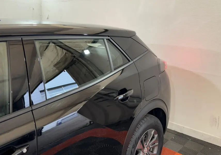 Vue latérale arrière droite d’un Peugeot 2008 noir brillant, mettant en valeur la porte arrière et la roue.