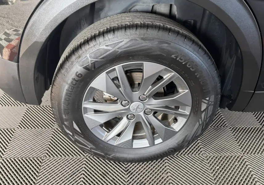 Gros plan sur la roue avant droite de la Peugeot 2008 noire, mettant en valeur la jante alliage et le pneu Continental.