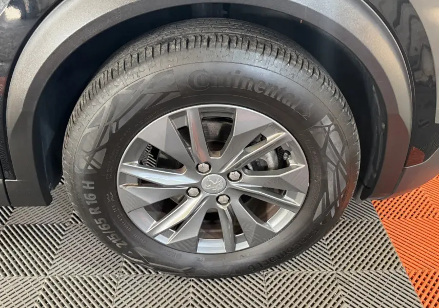 Gros plan sur la roue avant gauche noire du Peugeot 2008 PureTech 130 S&S ACTIVE PACK avec jante alliage grise.