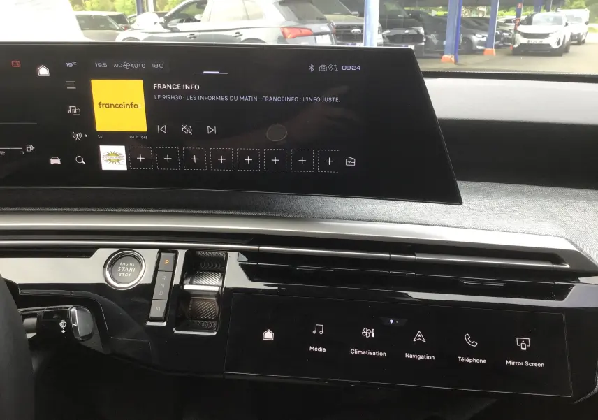 Vue intérieure du tableau de bord du Peugeot 3008 1.2 Hybrid 145 Allure, avec écran tactile central affichant France Info.