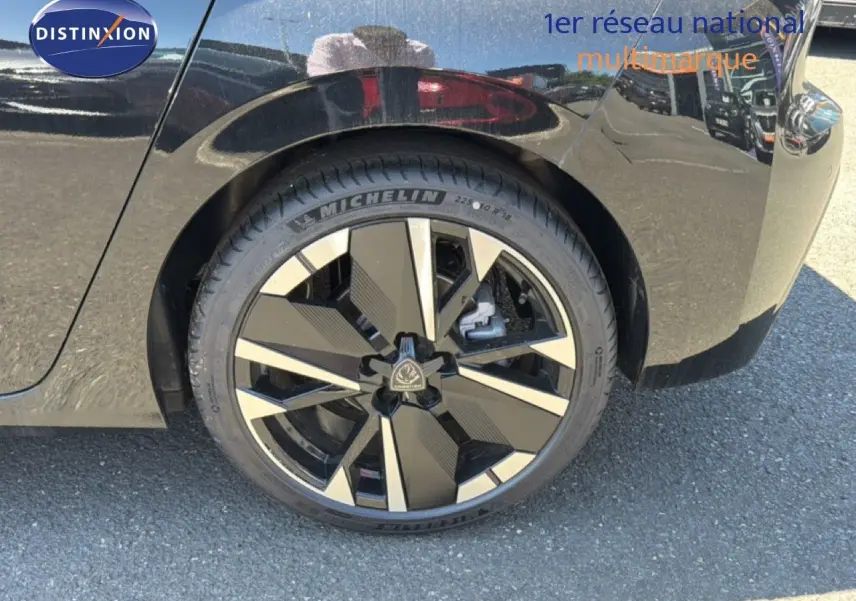 Gros plan sur la roue arrière droite d'une Peugeot 308 Hybrid 145ch GT noir perle métal, jante alliage au design moderne.