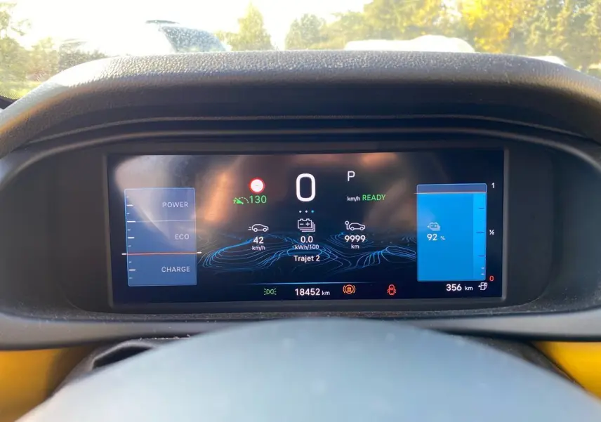 Vue du tableau de bord numérique du Jeep Avenger électrique 2023, affichant l'autonomie et la vitesse à l'arrêt.