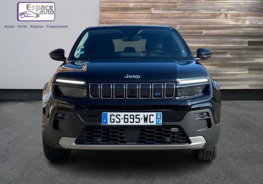 Vue de face d'un Jeep Avenger électrique noir 2023 avec calandre à sept barres et logo bleu "e" distinctif.