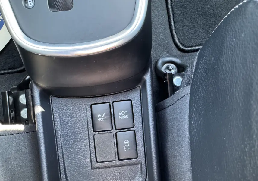 Gros plan sur les boutons de modes EV et ECO au centre de la console d'une Toyota Yaris Hybride blanche 2020.