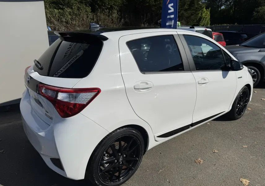 Toyota Yaris Hybride 100CH GR SPORT blanc vue 3/4 arrière droit avec jantes noires et vitres teintées.