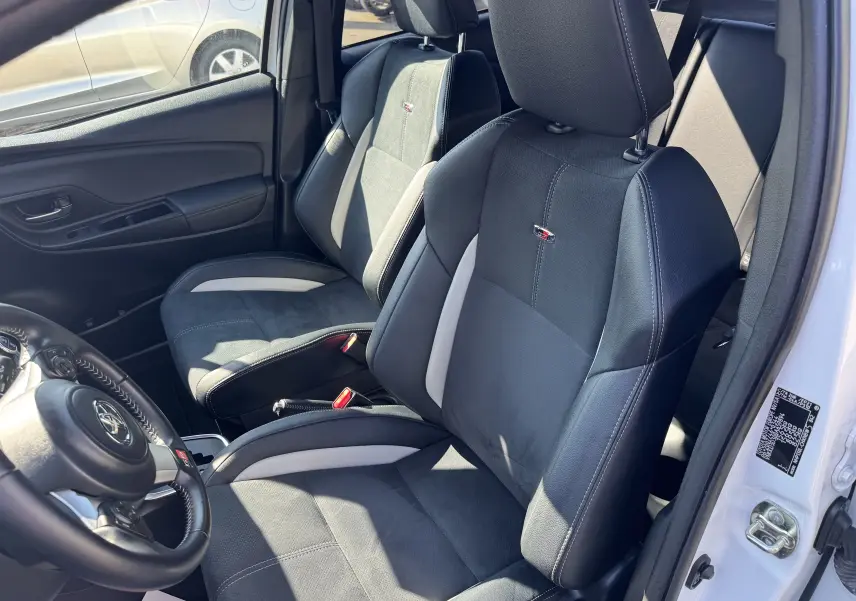 Vue intérieure côté conducteur de la Toyota Yaris Hybride GR Sport 2020 avec sièges noirs et inserts gris clairs.
