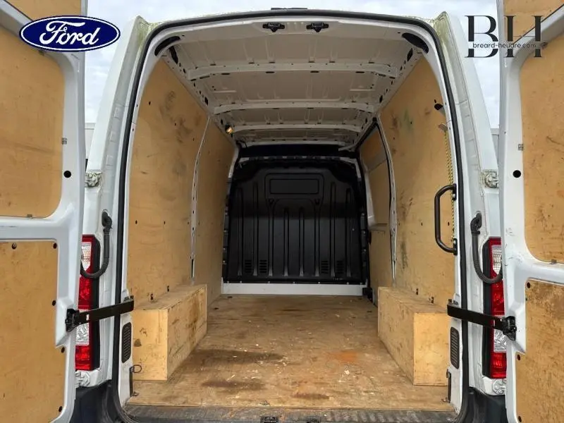 Vue arrière intérieure d'un utilitaire Renault Master blanc minéral avec aménagements en bois sur les parois et le sol.