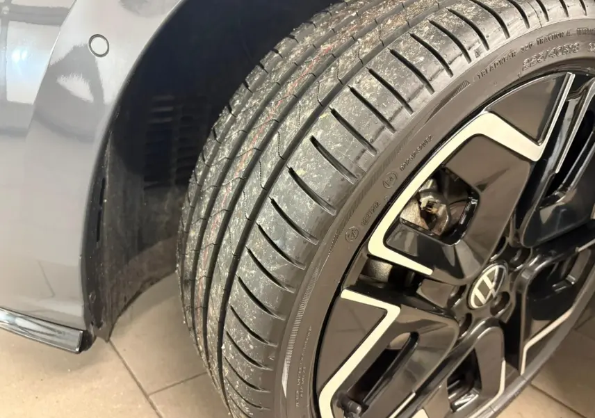 Gros plan sur la roue avant droite d'une Volkswagen Golf 1.5 eTSI 150 DSG7 R-Line Edition gris dauphin avec jante noire et argent.