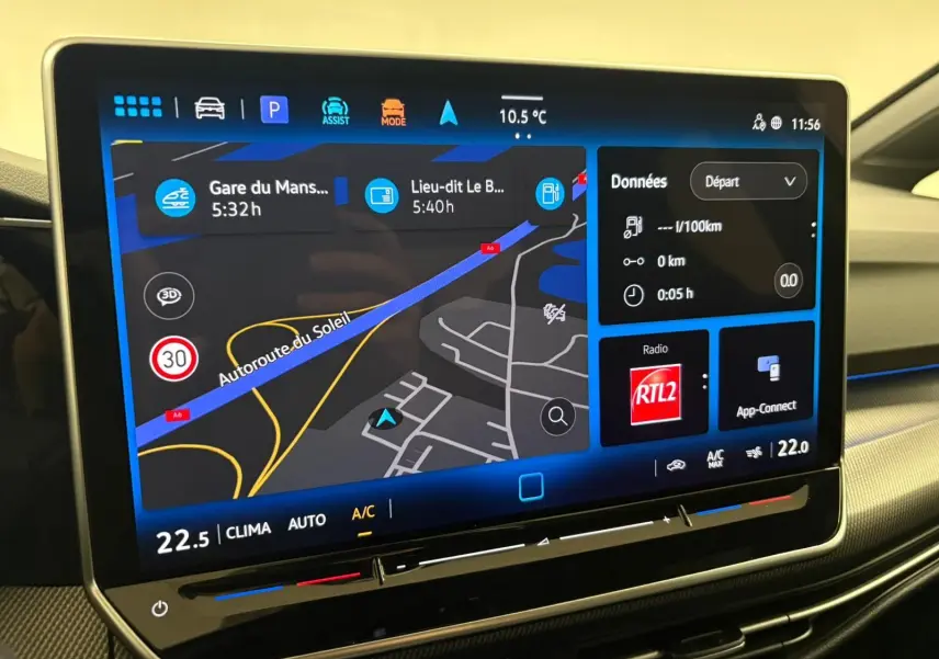 Écran tactile central de la Volkswagen Golf 1.5 eTSI 2025 affichant la navigation et la climatisation, intérieur gris.