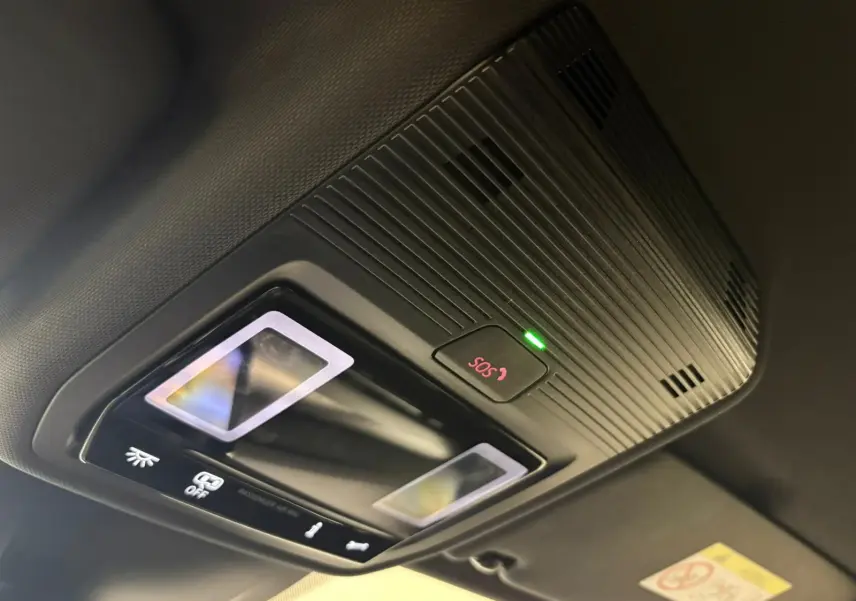 Gros plan sur le plafonnier intérieur avec bouton SOS illuminé en rouge dans une Volkswagen Golf Gris Dauphin 2025.