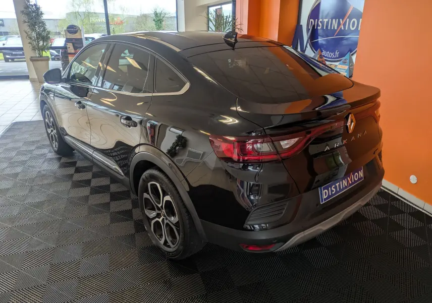 Renault Arkana noir en 3/4 arrière droit, mettant en valeur ses feux arrière et ses jantes bi-ton élégantes.