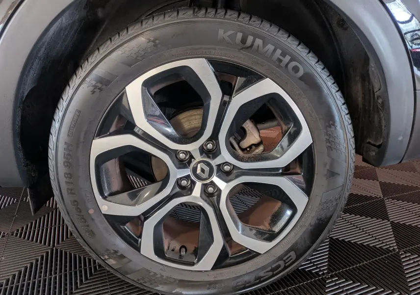 Gros plan sur la roue arrière droite du Renault Arkana noir 2023, montrant le pneu et l'arche de roue.