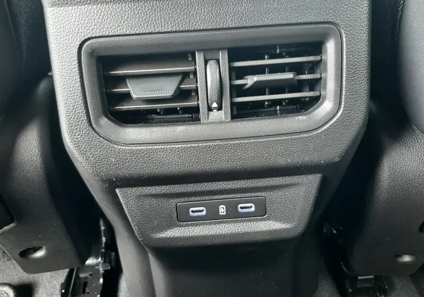 Détail de la console arrière noire avec bouches d’aération et deux ports USB-C du Renault Austral blanc nacré 2026.