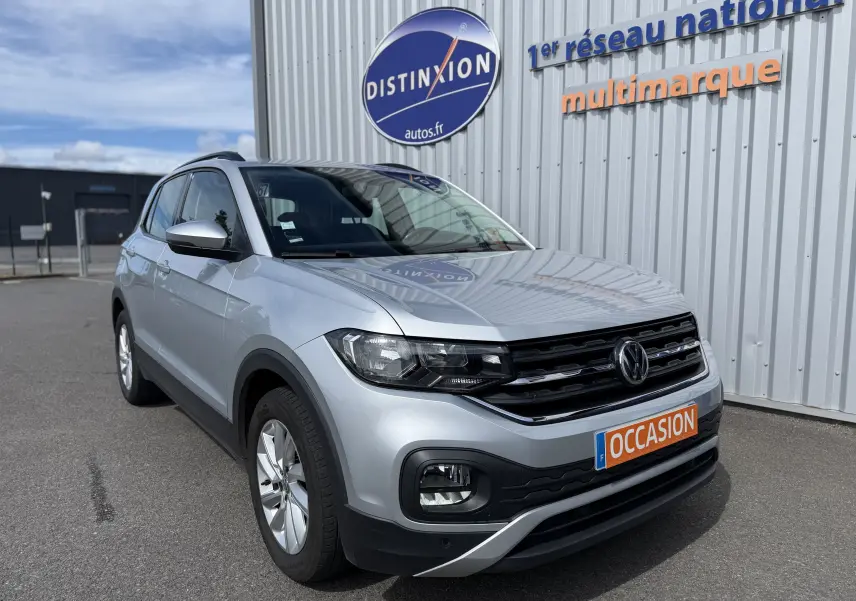 Volkswagen T-Cross gris 3/4 avant droit, SUV compact avec calandre noire et jantes alliage 16 pouces.