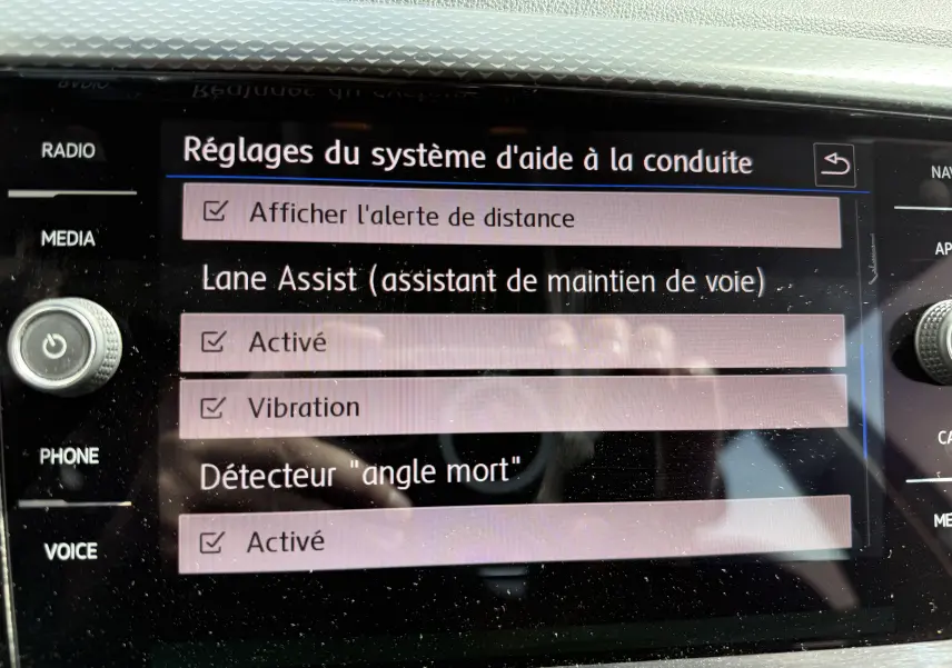 Écran tactile du système d’aide à la conduite du Volkswagen T-Cross 1.6 TDI 95 Lounge Business affichant les réglages d’alerte et d’assistance active.