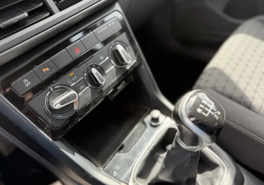 Gros plan intérieur sur la console centrale et levier de vitesses manuel d’un Volkswagen T-Cross gris 2019.